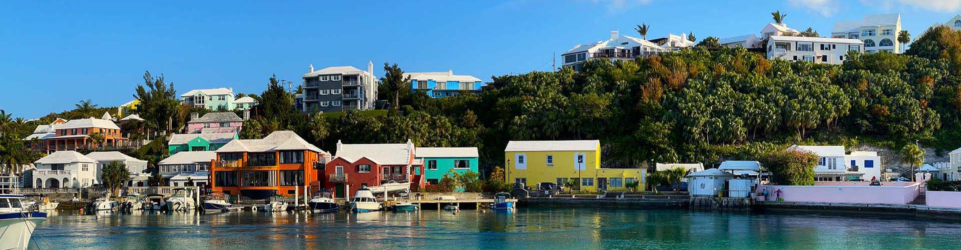 Colourful Bermuda houses along the harbour with boats moored at the waterfront